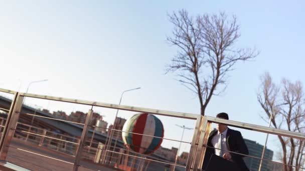 Businessman in jacket and tie jumps over an obstacle on background city — Stock video