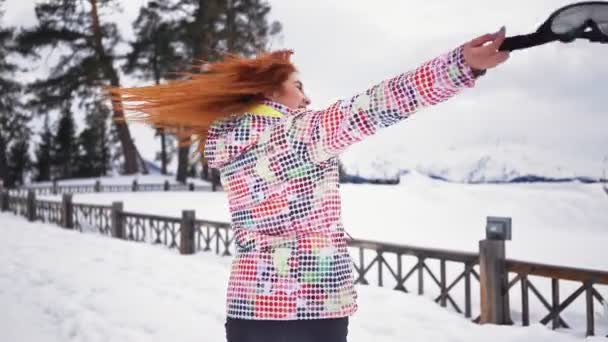 Счастливая девочка в вихрях и смолах снежных гор и леса — стоковое видео