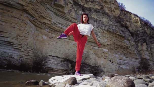 Chica se divide en el fondo del río de montaña y rocas. La mujer practica yoga — Vídeos de Stock