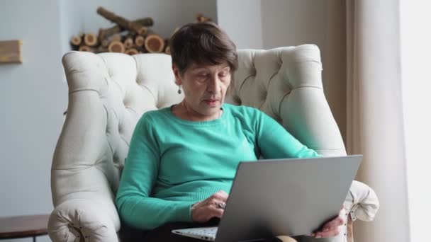 Anciana mujer aprender a trabajar en el ordenador portátil. Pensionista Problemas para entender la tecnología — Vídeos de Stock