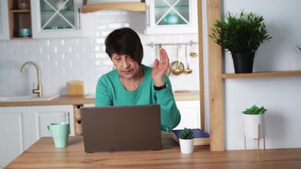 Mulher idosa trabalhando remotamente no laptop Senhora velha está digitando no teclado do notebook — Vídeo de Stock