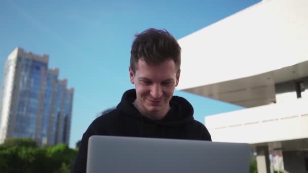 Szczęśliwy facet korzysta z laptopa i uśmiecha się podczas oglądania filmów w Internecie — Wideo stockowe