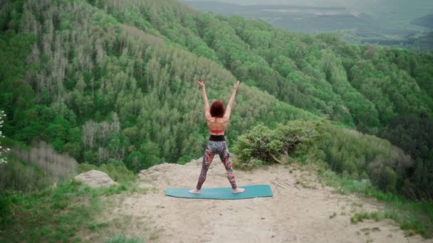 Sportowa kobieta ćwiczy jogę na szczycie góry. Slim dziewczyna idzie w sporcie na zewnątrz — Wideo stockowe