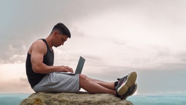 Sportovní muž na volné noze Práce na notebooku a těší úspěch ohromující scenérie — Stock video