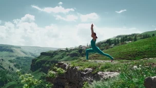 La ragazza atletica pratica yoga sulla montagna di bordo. Slim Donna Allenamento all'aperto — Video Stock