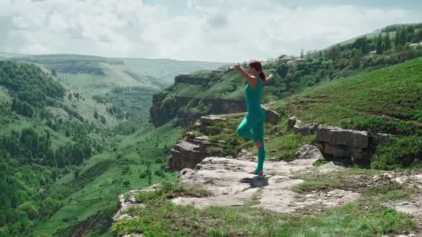 Atletisch meisje oefent yoga op de Edge Mountain. Slanke vrouw workout buiten — Stockvideo