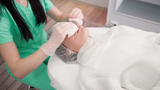 Kobieta kosmetyczka robi zabiegi oczyszczania twarzy pacjenta. Pielęgnacja skóry i ciała Spa — Wideo stockowe
