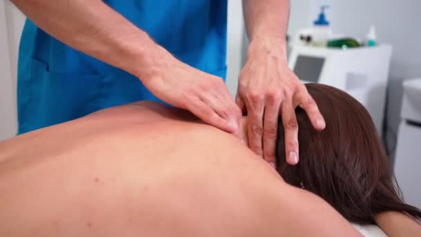 Nerozpoznatelný muž profesionální masér dělá masáž štíhlé dívka v lázeňském salonu. — Stock video
