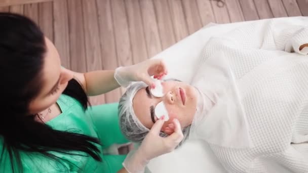 Mujer esteticista hace que el tratamiento facial de la piel paciente femenina en el salón de belleza — Vídeo de stock