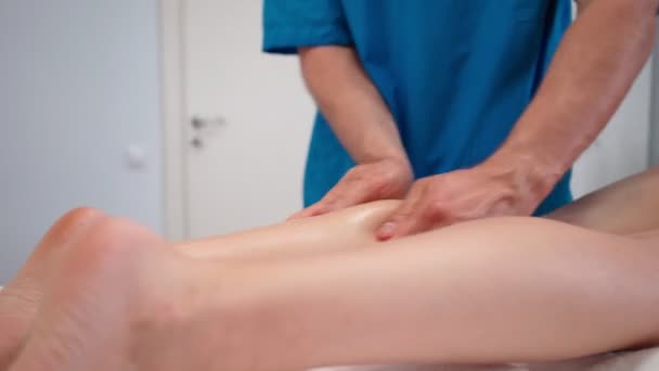 Nierozpoznawalny mężczyzna profesjonalny masażysta sprawia, że nogi masażu szczupła dziewczyna salon spa — Wideo stockowe