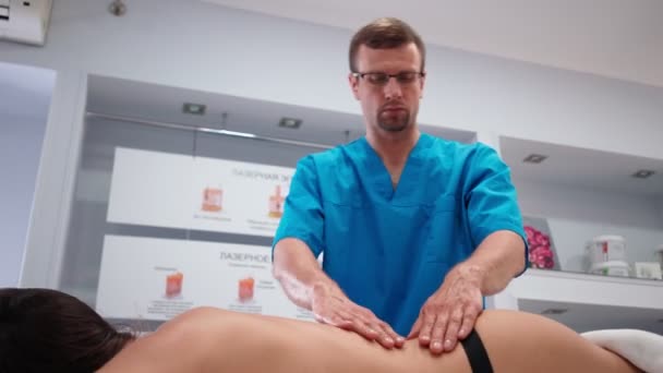 Mężczyzna profesjonalny masażysta robi a masaż dla a szczupły dziewczyna klient w spa salon. — Wideo stockowe