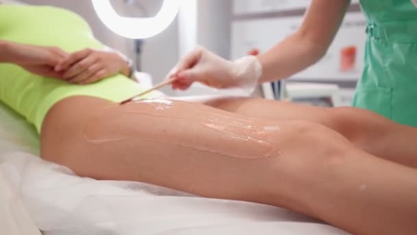 Жінка - красуня готується до судового процесу для усунення лазерного волосся - жіночих ніг — стокове відео