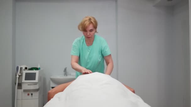 Массажист для взрослых делает лечебный массаж спины красивой девушкой в спа-салоне — стоковое видео