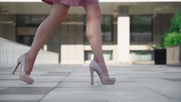 Yakından bakınca, şehrin caddesinde yürüyen yüksek topuklu seksi kadın ayakları görülüyor. — Stok video