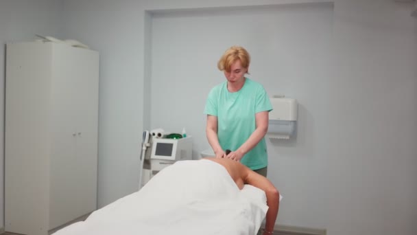 Felnőtt nő masszőr teszi terápiás hátmasszázs gyönyörű lány spa szalonban — Stock videók