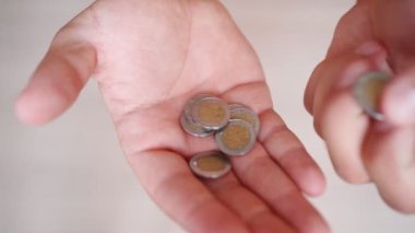 Adam evde otururken Meksika pesolarını sayıyor. Yoksulluk ve Ekonomik Kriz