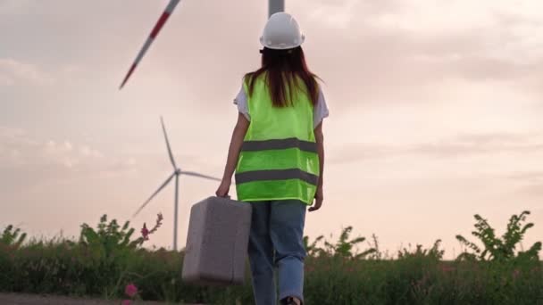 Kvinnans ekologi specialist med särskild utrustning i handen går till service väderkvarn — Stockvideo