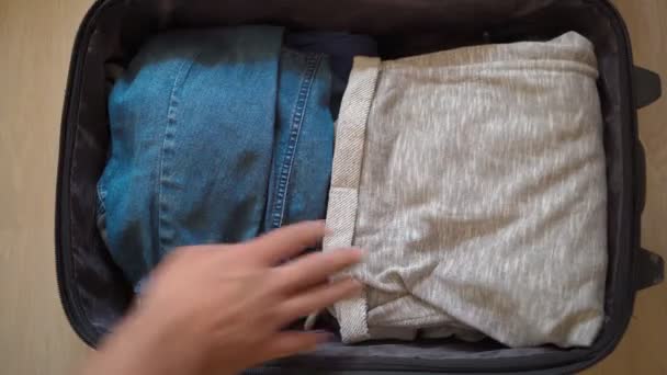 男子将衣物放在手提箱内，并在度假时抛掷成堆的医疗面具 — 图库视频影像