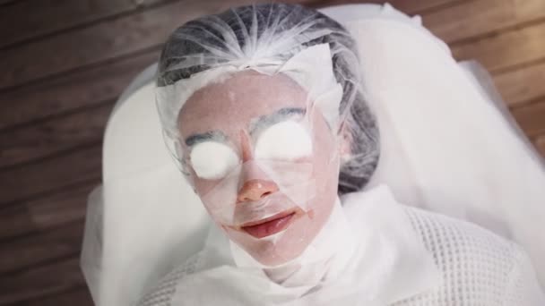 Kvinna som ligger på medicinsk soffa under ansiktsföryngring förfarande skönhetssalong — Stockvideo