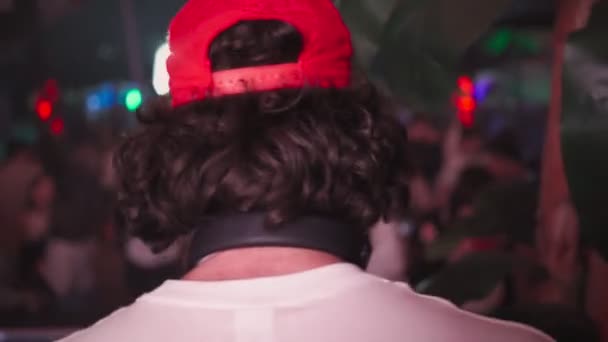 DJ irreconocible contra el festival de música de fondo en el club nocturno. Fiesta nocturna. — Vídeos de Stock