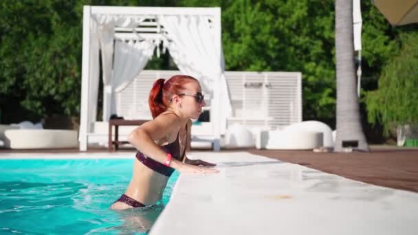 Belle femme en maillot de bain avec une belle silhouette sort de la piscine — Video