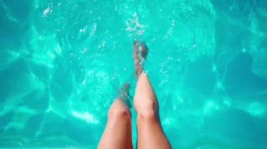 Tanımlanamayan ince kadın bacakları sıcak bir yaz gününde havuza düşer..