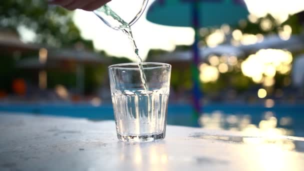 Grünes Erfrischungsgetränk wird aus Flasche in gläsernen Pool geschüttet. — Stockvideo