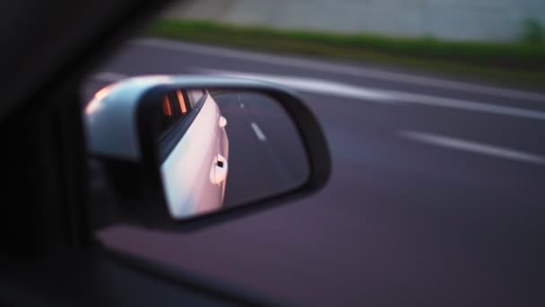 Ver en el espejo lateral del coche que está conduciendo rápido en la carretera adelantar a otros coches — Vídeos de Stock