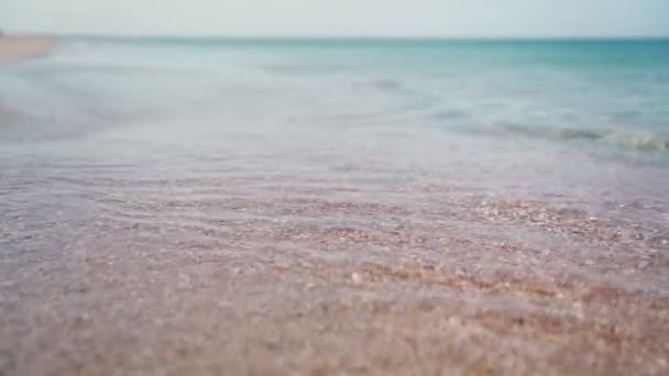 Playa y mar turquesa claro en el día soleado. Vacaciones de verano. Movimiento lento. — Vídeo de stock