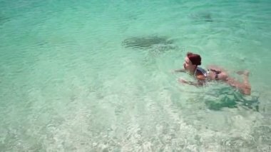 Sıska bir kadın güneşli bir günde açık denizde yüzer yaz tatili konsepti