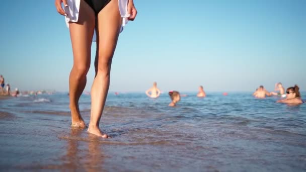 Sexy pernas femininas andando ao longo da praia ao longo do mar Mulher caminha descalça na água do mar — Vídeo de Stock