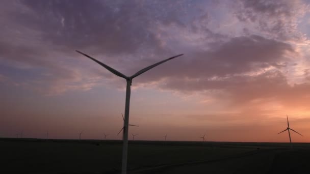 Letecký pohled. Větrná farma pracuje na pozadí krásného západu slunce — Stock video
