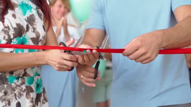 Супружеская пара открывает собственный бизнес по перерезанию красной ленточки в честь открытия нового магазина — стоковое видео