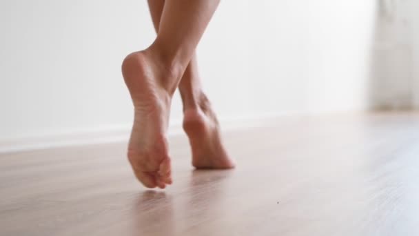 Slim female bare feet walking white wall. Attractive legs woman gracefully walk — Stock Video