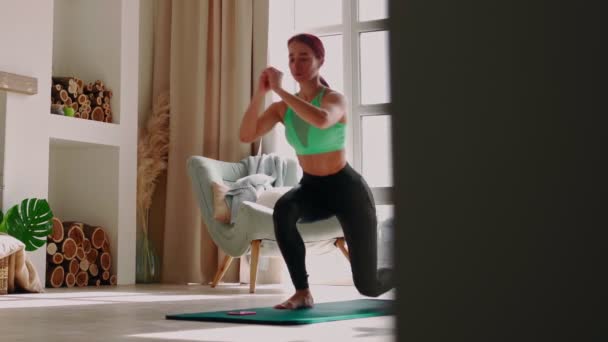 Женщина упражняется дома. Спортивная спортивная девочка, занимающаяся аэробными упражнениями — стоковое видео