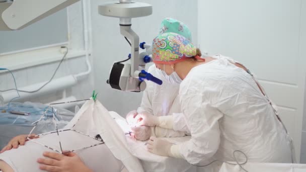 Dos cirujanas realizan cirugía ocular con microscopio e instrumentos médicos — Vídeo de stock