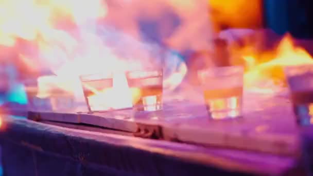 Gros plan d'un barman préparant des cocktails et mettant le feu à des boissons alcoolisées — Video