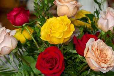 Renkli kırmızı, pembe ve sarı güllerden oluşan bir buketin tam çerçeve dokusu, güzel bir çiçekçi düzeninde, çözünmüş arka planda.