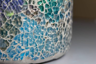 Bu resim seramik kaplarda mozaik tasarım cam seramik parçalarının mozaik desen arkaplanını boyalı cam görünümlü bir makro-soyut gösteriyor..