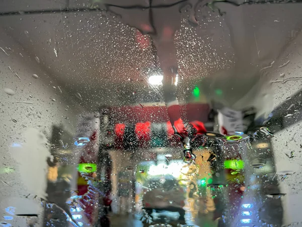 この画像は 自動車のフロントガラスに石鹸液やリンス水のパターンやデザインを示す自動洗車機の抽象的な芸術のテクスチャの背景を示しています — ストック写真