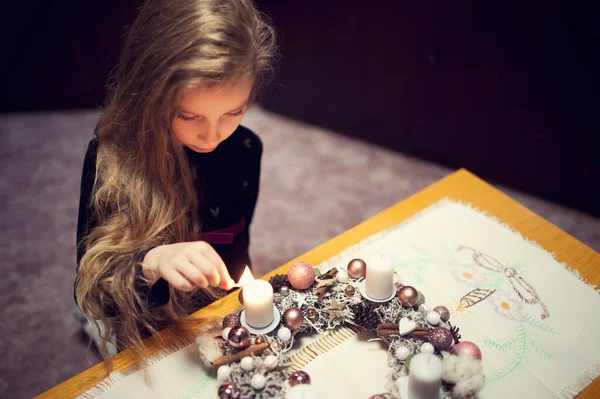 Advent 'in ilk pazar günü. Küçük kız çelengin ilk mumunu yakıyor. Noel kutlaması geliyor.