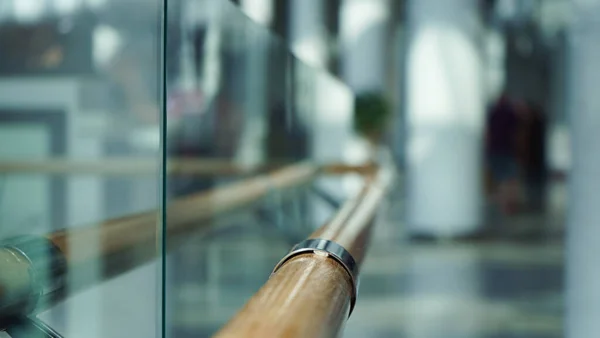 Wooden railings and glass wall in a large shopping center for the comfort of shoppers, modern design.Close-up, selective focus, blur.