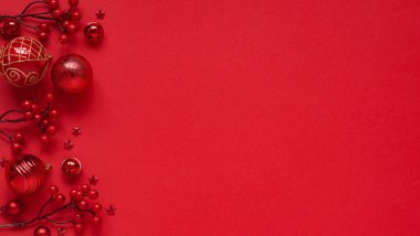 Yeni Yıl ve Noel afişi için kavram. Kırmızı zemin üzerinde Noel dekoru, kırmızı toplar, böğürtlen ve yıldızlar, üst görünüm, düz konum, kopyalama alanı. Yazılar ve harfler için ayrılmış noel kartı..