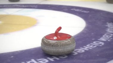 Beyaz buza kıvrılmak için granit taşlar. Kış sporu, takım oyunu. Curling Kulübü. 4K video.