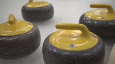 Beyaz buza kıvrılmak için granit taşlar. Kış sporu, takım oyunu. Curling Kulübü. 4K video.