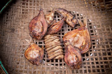 Güneşli bir günde güneşte kurutulmuş tuzlanmış balık harman sepetinde kurutulmuş balık. Tuzlu kuru yılan derisi gourami doğal güneş kurutma yöntemiyle işleme ve korunma kavramı.