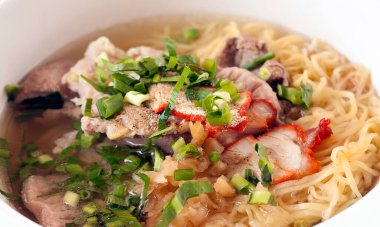 Erişte çorbası, kırmızı domuz eti ve domuz ciğeri üstüne soğanlı erişte geleneksel Tayland sokak yiyecekleri masaya..