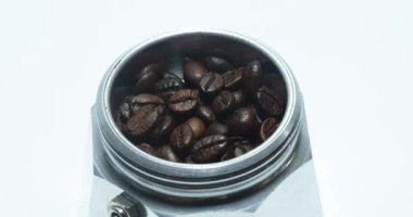 Moka Pot 'taki Stop Motion Kahve Fasulyeleri Moka kahve demliğini beyaz arkaplanlı kahve çekirdeğiyle yapmak için gerekli malzemeleri kapatın..