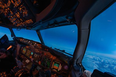 Modern yolcu uçağının uçuş güvertesi, pilotlar mavi saatte seyir halinde. Güneş batarken bir jet uçağının kokpitinden güzel bir ışık.