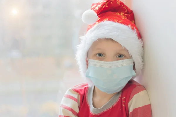 Pré Escolar Uma Máscara Médica Gorro Ano Novo Olha Para — Fotografia de Stock